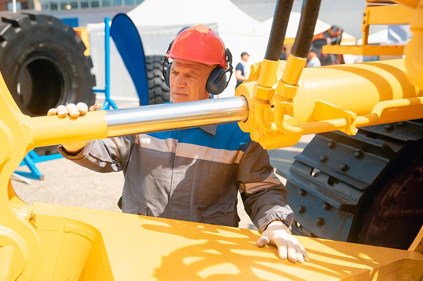 Trabalhador manuseando escavadeira hidráulica