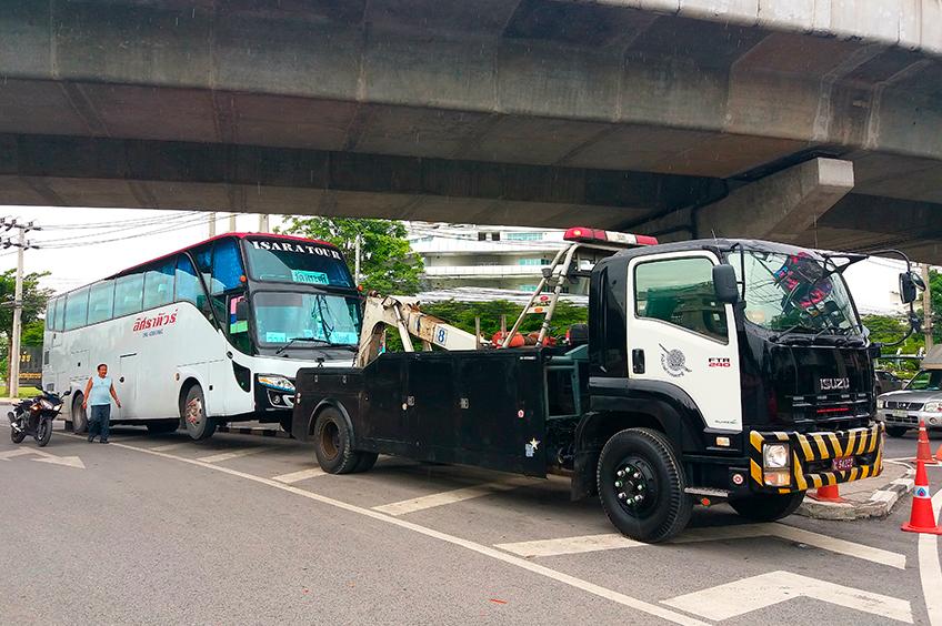 Caminhão guincho transportando ônibus